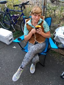 Leidi Monte Person seated outside, holding coffee cup and smiling up into camera Leidi Monte